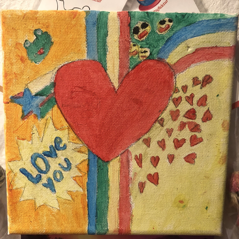 Ein Muttertagsbild. Zu sehen ist ein Grußes rotes Herz in der Mitte auf gelblichem Hintergrund. Links vom Herz steht: LOVE YOU in einer Platzblase und eine blau-bunte Sternschnuppe, rechts verteilen sich kleine rote Herzchen unter einem Regenbogen, der sich aus dem Sternschnuppenschweif ergibt