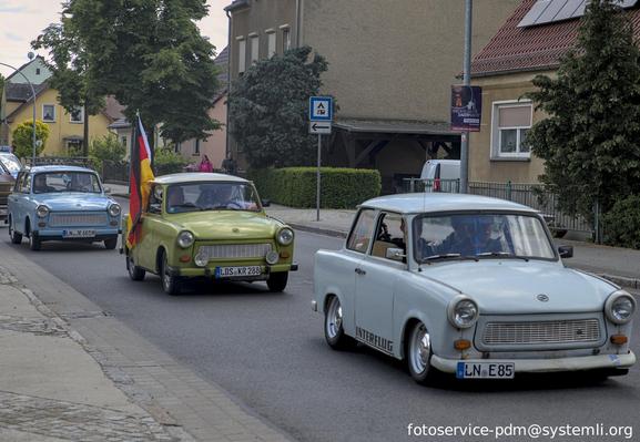 drei trabbis des autokorso, aus einem wird eine deutschlandfahne gehalten