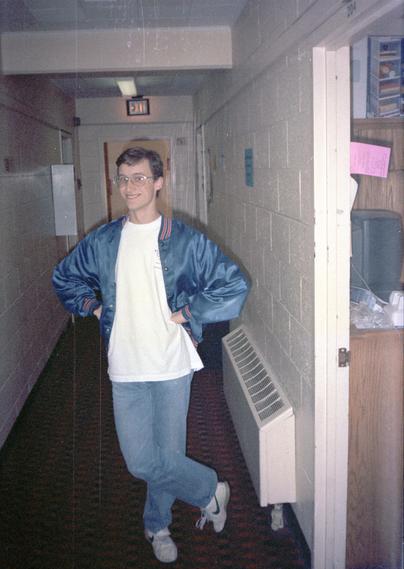 A much skinnier Dave Tabb stands on the psychedelic carpet of Buchanan-Droke residence hall.  He is wearing a nylon jacket that was so staticky it used to make his hair stand on end.  Several scratches are visible in the picture due to shuffling the negative in and out of a plastic storage sleeve.