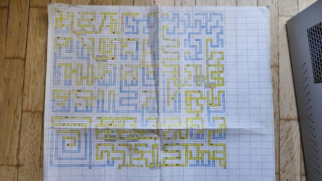 A hand-drawn map of the maze from the C64 game Hero of the Golden Talisman. It's drawn on four pieces of squared paper glued together. The corridors are colored with yellow and blue pencil — blue for the underwater sections, yellow for the regular passageways.