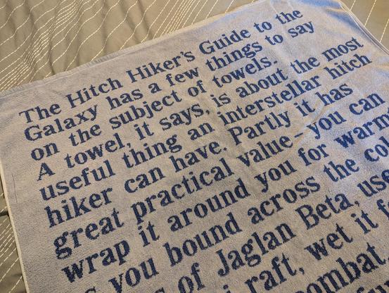 An official 80s "Hitch Hiker's Guide to the Galaxy" towel, the one with the text of the Guide's entry on towels on it in friendly blue text.
