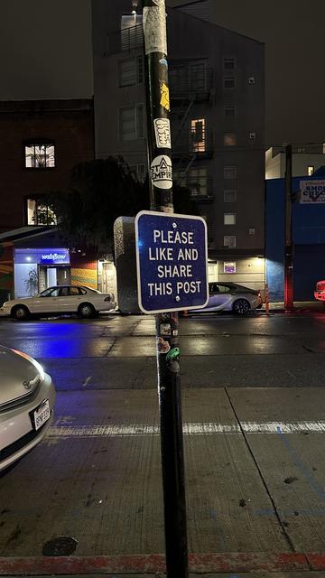 Street lamp with a sign that says Please like and share this post.