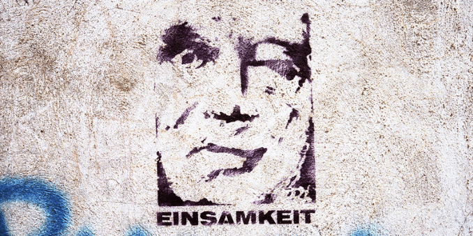 „Einsamkeit“ von loranger ist lizenziert unter CC BY 2.0. Zu sehen ist ein Graffiti auf einer grauen Wand, das Graffiti ist ein Porträt eines älteren Menschen in Negativ gesprayt, unterm Porträt steht das Wort "Einsamkeit".