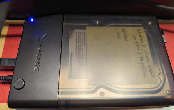 Photo of my new Sabrent USB 3 drive dock. It lets you connect an internal drive drive to your computer so you can access it just like any other drive. It's made from black plastic, with a transparent lid that lets you see what's inside. A blue power light appears in the upper left corner.

The dock will accept 2.5" and 3.5" drives, which is super handy for all sorts of data copying tasks.