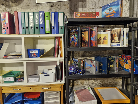 Un détail du rayonnage des jeux et jouets de la Ressourcerie, photo prise le samedi 24 mai 2025. Sur plusieurs étagères, on trouve des classeurs de bureau, des boîtes de jeux et plusieurs puzzles...

Dont deux puzzles reprenant les couvertures de deux albums du groupe de rock progressif Mastodon (maintenant, ils sont chez moi !).