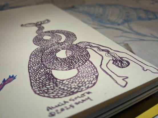 Sketchbook photographed at an angle, a long tailed merperson coils in purple.