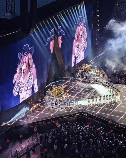 Beyoncé on stage in a glam cowgirl outfit, her dancers in a V formation