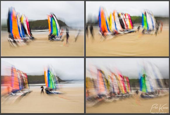 Copie partielle d'écran présentant quatre photos de la ligne de départ d'une compétition de chars à voile sur une plage de sable, captées en pratiquant un mouvement intentionnel lors de la prise de vue : une rotation de l'ensemble boîtier et objectif autour de l'axe de l'objectif pour les deux premières photos, et un zooming pour les deux suivantes. Le ciel est couvert au-dessus de la plage, avec une falaise en arrière-plan. Les voiles sont de couleurs vives, particulières pour chacun des chars.