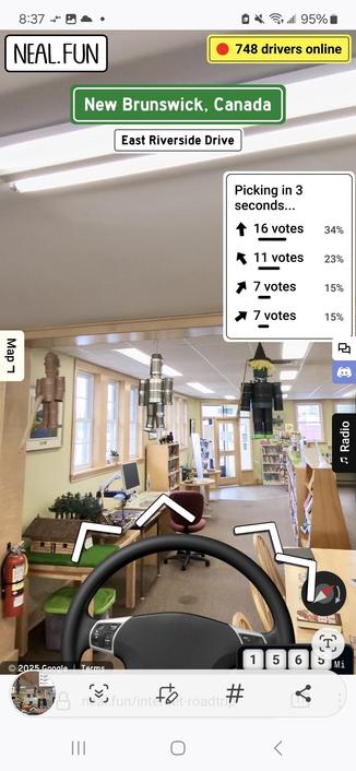 interior of a library with yellow walls,  diorama, tables & chairs, shelves of books, & 3 doll figures hanging from the ceiling beams.  a car steering wheel is superimposed over top