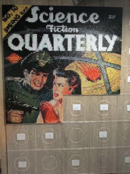 It's the top half of a magazine cover. The title "Science Fiction Quarterly" is in white beads on top. The image shows a man behind a woman, both looking at each other with anger.