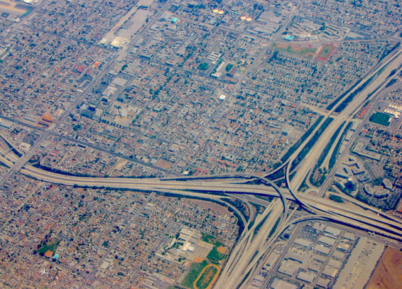 an aerial photo of LA< shot from a plane, shows the intersection of two huge highways, surrounded by a sea of small buildings