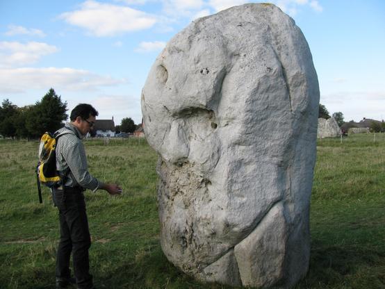 A dowser dowsing one of the standing stones in Avebury stone circle.