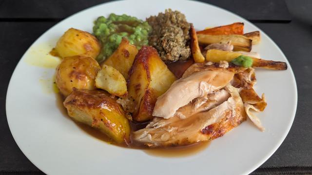 A white plate with all of the previously mentioned items of food on it, and the smothered in gravy made from the juices of the chicken.