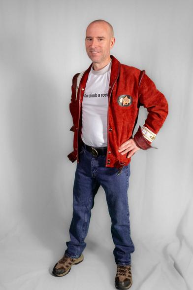 Photo of myself in blue jeans, a white T-shirt with the text "Go climb a rock." across the front, and a maroon bomber-style jacket with Starfleet insignia.