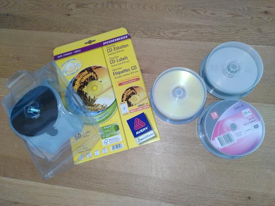Drei Behälter mit Rohlingen, eine Packung Selbstklebe-Etiketten und eine Positionierhilfe.