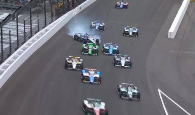 Marco Andretti's IndyCar, sliding at an angle, wheels smoking.