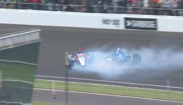 Marco Andretti's IndyCar, sliding, fully-sideways, at speed, a second race car in the smoke peeling off Andretti's tires.