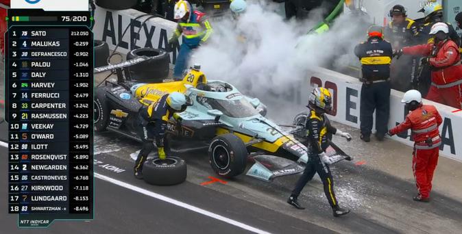 Smoke, steam, and flame retardant spray roll off race car as flames are extinguished.
