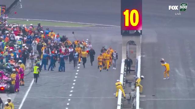 The pit crew rushes on to the track to meet Alex Palou.