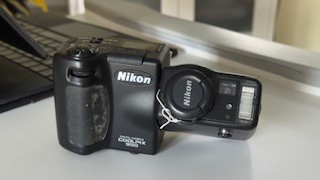 This is a Nikon Coolpix 950 camera, still functional. Still fun to use, though slow and very low resolution compared to current equipment. It was a very pocketable and convenient twist camera with both a rangefinder and a live display on the back. Closed, it is the size of a small brick cut lengthwise. It took lots of good pictures.