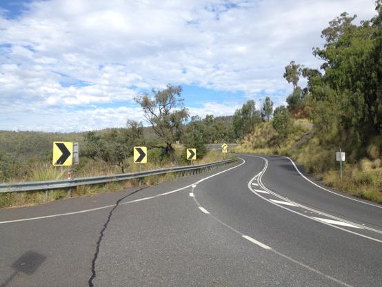 A view of the road going up Mount Morgan, where it curves to the right, left then hairpins right and continuing out of frame.