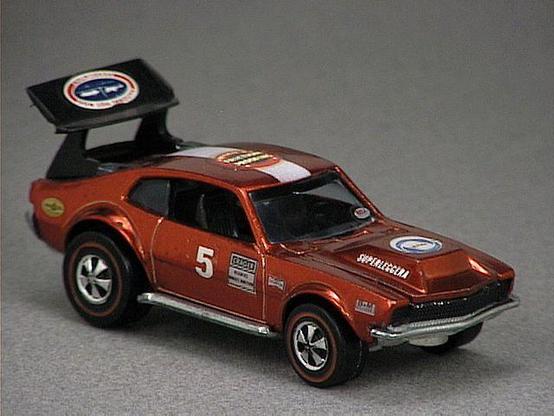 Released in 1970, Spectraflame Brown Mighty Maverick of 1970 Hot Wheels with Redline wheels. Notes: Hood lifts up to reveal a metal engine. comes with a black or white stripe on roof, black plastic rear spoiler. US version has a thicker stripe on the roof and black headlights. Packaging: 1970 Blister. Metal Body, Metal Base. Made in USA. Scarcity: 8/10