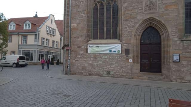 Transparent mit "Ausstellung - Entfernung von der Truppe - Desertion im NS" an der Michaeliskirche in Erfurt.