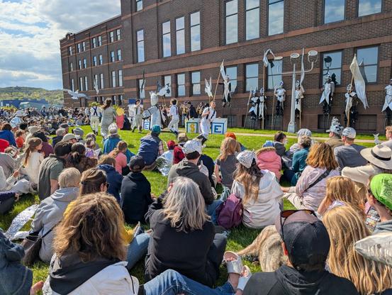 Crowd watching a performance by the Magic Smelt Puppet Troupe in Duluth by the Aerial Lift Bridge