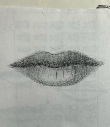A pair of lips drawn using pencil on scrap paper