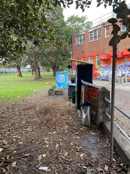 The food and supply cupboards set up near the wall of the little park. Volunteers brought in some wood chips to help stabilise footing around the cupboards after the deluge of rain we've had.