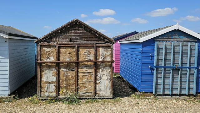 A view of coloured beach huts with security doors.