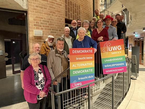 Gruppenbild der Kandidat*innen der UWG Selm für die Kommunalwahl in NRW 2025, Präsentation bunter Wahlplakate