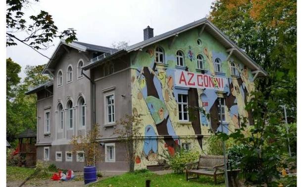 Dreistockiges Haus mit bunter Fassade auf de steht "AZ Conni"