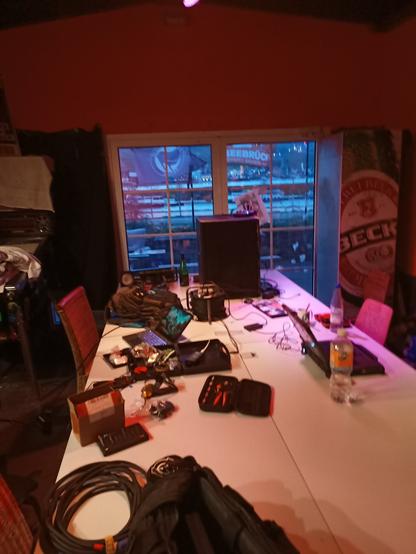 Es ist ein großer Tisch zusehen auf dem Werkzeuge und Laptops liegen. Im Hintergrund am Ende des Tisches steht ein großer Lautsprecher.