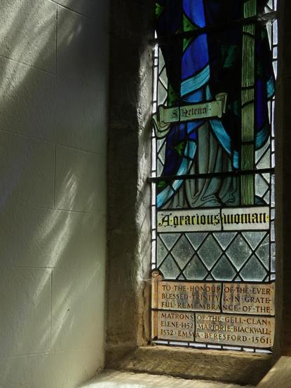 Part if a stained glass window throwing shadows onto the wall