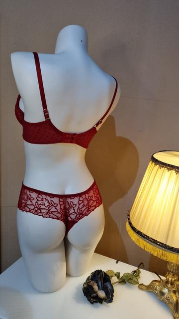 Rückenansicht des roten Sets mit String. Der String hat breite Seiten und ist in der Rückenansicht komplett transparent mit samtiger Blumenspitze.