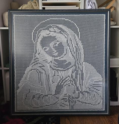 Framed large crocheted tapestry in white, depicting Virgin Mary praying.