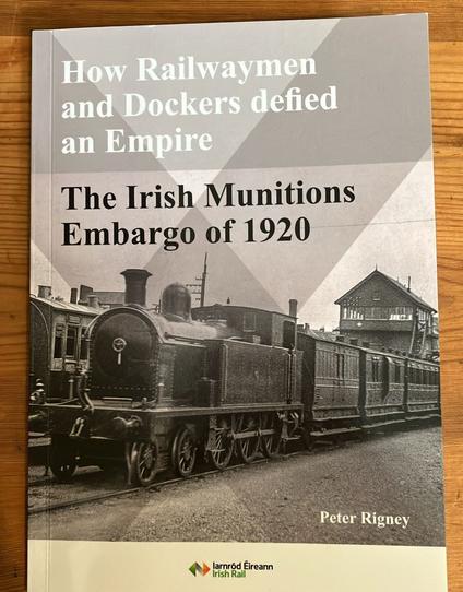 How Railwaymen and Dockers defied an Empire: The Irish Munitions Embargo of 1920 by Peter Rigney. Grey book on wooden table.