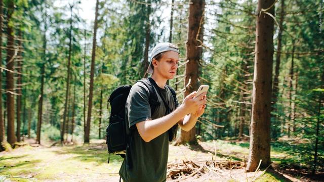 Mann im Wald sucht nach Handynetz: So kannst du helfen, das Mobilfunknetz in Deutschland zu verbessern (Foto: Adobe Stock, Serhii)