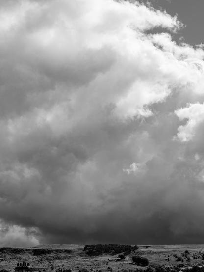 Monochrome photo. Deep and heavy cloud over a moorland edge.