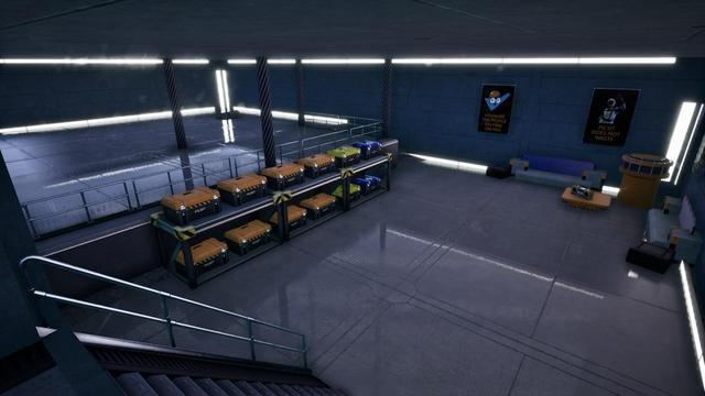 Interior of a room. The floors are shiny and smooth. Storage crates are stacked in a line. Posters hang on a wall behind a lounge and coffee table. Strip lights highlight the edges of the walls.