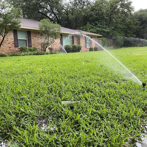 Lush green lawn with sprinklers going
