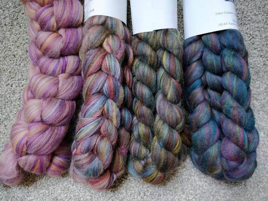 Four braids of combed merino top (spinning fibre) in a gradient from pink through dark blue.