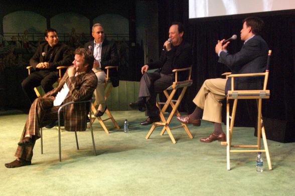 A panel of four men in tall director-style chairs, from left to right, Hank Steinberg, Ross Greenburg, Billy Crystal, and Bob Costas, and sitting in front of them in a shorter chair, Thomas Jane.