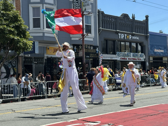 Man in stilts carrying a flag