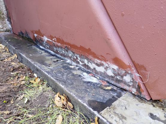 Wet fiberglass patch over the bottom edge of the bulkhead door. There are areas where the cloth is white, which are the areas where rust had eaten all the way through the material.