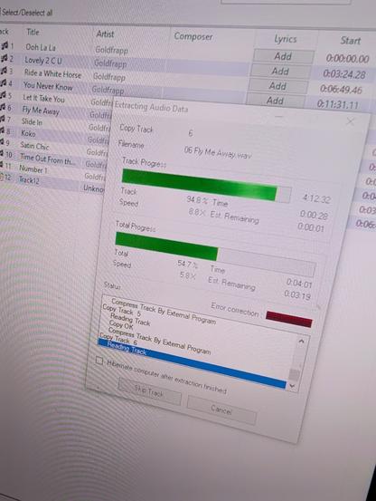 A photo of a computer screen. It shows the application "EAC" (Exact Audio Copy) running. It is  extracting a CD by Goldfrapp.