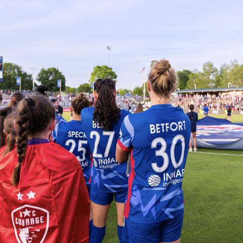 Starting XI on the field for the national anthem ahead of a match looking at the American flag