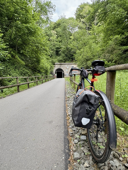 Gravelrad vor dem Tunnel Schee, an ein Absperrgitter lehnend.
