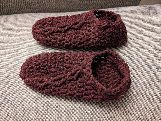 my completed slippers for Mom, with the cables angling diagonally across the top of the foot